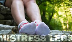 Mistress teases feet in white socks outdoors in the forest