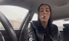 Smoking in car wearing leather gloves and jacket