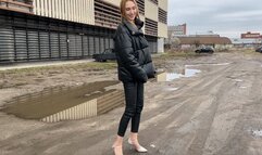 girl walks along a muddy road and gets her shoes and feet dirty