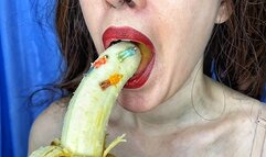 The giantess is sucking a banana on which tiny people