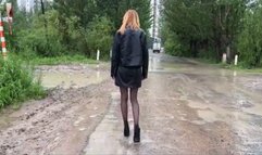 A girl in high-heeled shoes walks through the mud, dirties them, dirt sticks to her sexy shoes