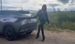 A girl in leather boots presses the pedals of a car, enjoys the sound of the engine and plays with her feet with the dashboard