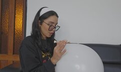 Marianna blows a white balloon full of red kisses to make it pop