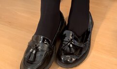 Shoeplay and dangling in black flat loafers and Doc Marten shoes with black pantyhose