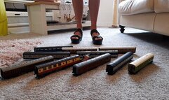 GIANTESS Charn crushes 10 toy model train coaches in black wedges closeup ground view