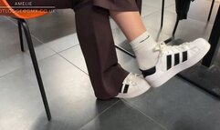 Candid shoeplay and dangling in Adidas sneakers and Nike white socks at the airport