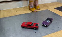 Giantess Atari queen destroys a Plymouth Road Runner & Dodge Challenger toy car crush in sexy yellow wedges close left view