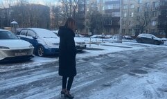 The girl went out for a walk in high heels, but she did not expect that it would be so slippery and there would be ice everywhere