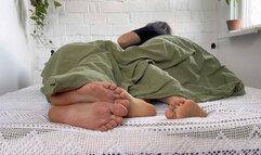 female male bare feet under the blanket