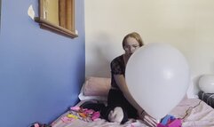 Cute girl pops balloons on electric pump