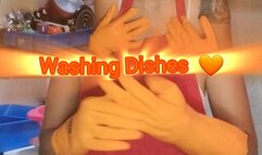 Washing dishes with orange gloves