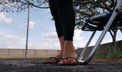 Diosa Angelin with her flip-flops dangling from her feet while cross-legged in the park (1)