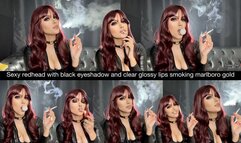 Sexy redhead with black eyeshadow and clear glossy lips smoking marlboro gold