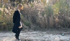 a girl walks in leather high boots, finds a watermelon and starts crushing it