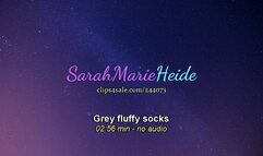 Big girl feet with grey fluffy socks