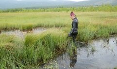 Pretty girl in leather leggings discovers swamp mud, walks, falls and gets stuck in swamp mud