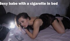 Sexy babe with a cigarette in bed
