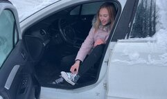 girl in the cold cannot start the car, the car only makes the sound of a starter, and the girl presses the pedals with her bare feet
