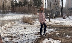 girl in high heels tries to climb an ice slide, but she fails