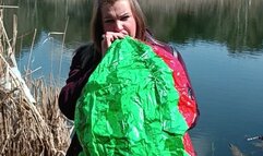 girl blowing big beachball on nature