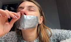 Sneezing with mouth taped and wiping nose with tissues