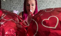 Girl blowing foil hearts balloons