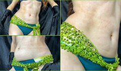 Belly dance with a shiny green belt on the hips